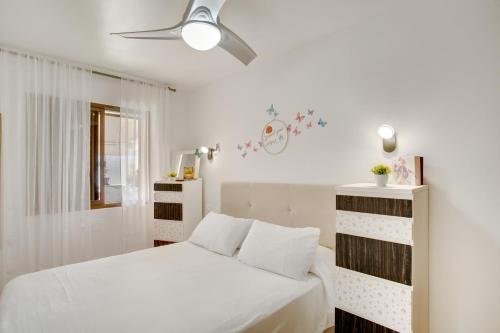 une chambre blanche avec un lit et un ventilateur de plafond dans l'établissement Esther Dream Bungalow, à Mogán