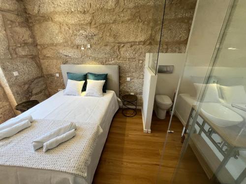 a bedroom with a king sized bed and a sink at Ameixial Suites in Porto