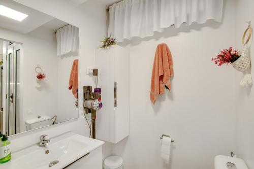 une salle de bains blanche avec un lavabo et un miroir dans l'établissement Esther Dream Bungalow, à Mogán
