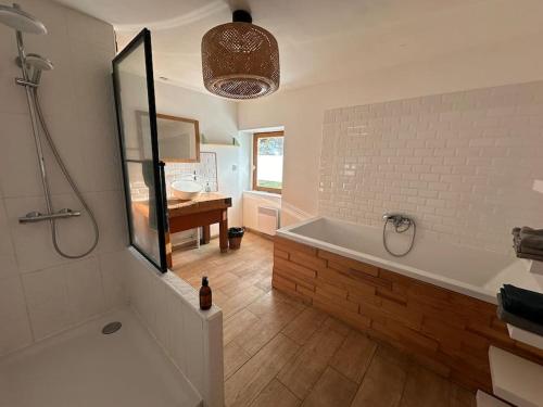 une salle de bain avec une baignoire et un lavabo dans l'établissement Jolie maison de campagne - La Ferme de Montigny, Orne, à Neauphe-sur-Dives