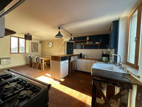 une cuisine avec un évier et une cuisinière four supérieur dans l'établissement Jolie maison de campagne - La Ferme de Montigny, Orne, à Neauphe-sur-Dives