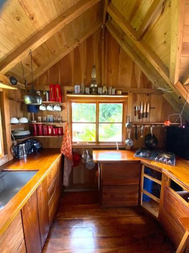 a large kitchen with wooden counters and a window at Magical Port Antonio Close to Blue Lagoon Frenchman's Cove in Port Antonio