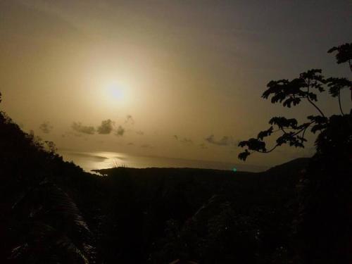 a sunset over the ocean with the sun in the sky at Magical Port Antonio Close to Blue Lagoon Frenchman's Cove in Port Antonio