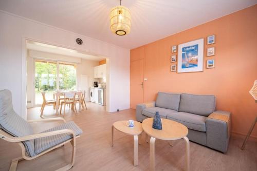 un salon avec un canapé, des chaises et une table dans l'établissement La Rafale rez de chaussée - Accès Privée à la plage, à Grand-Fort-Philippe