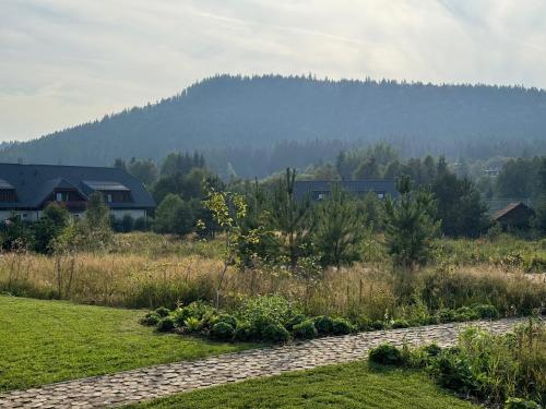 a stone path in a field with a mountain in the background at Apartmány Černý vlk, Borová Lada in Borová Lada