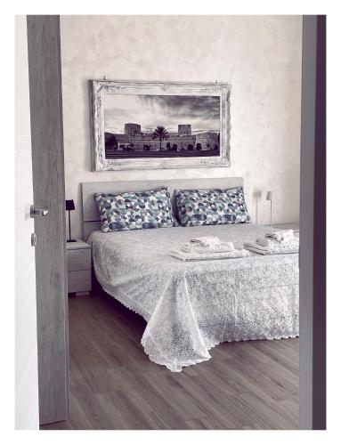 a bedroom with a bed with a picture on the wall at Suite gargano 10 in Manfredonia