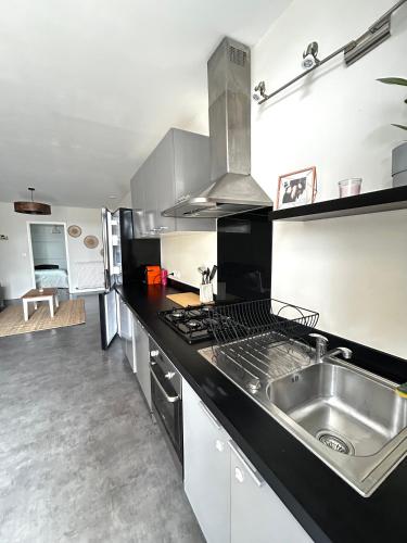 une cuisine avec un évier et une cuisinière dans l'établissement Escapades cosy au cœur des vignes, à Cézac