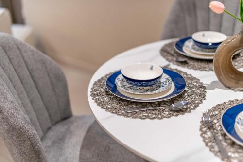 a white table with blue and white dishes on it at Luxury Saadiyat Soul Beach Residence in Abu Dhabi