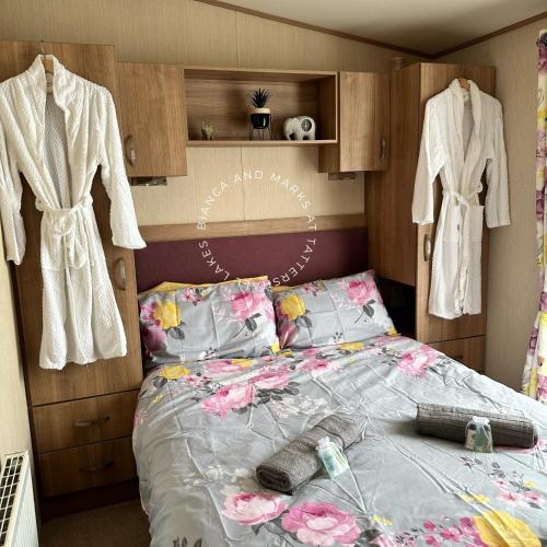 a bedroom with a bed with flowers on it at Bianca and marks 8 berth Caravan with Hot tub in Tattershall