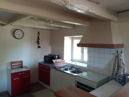 une cuisine avec un évier et une cuisinière four supérieur dans l'établissement Gîte à la campagne, bain de soleil ou coin du feu, à Tulle
