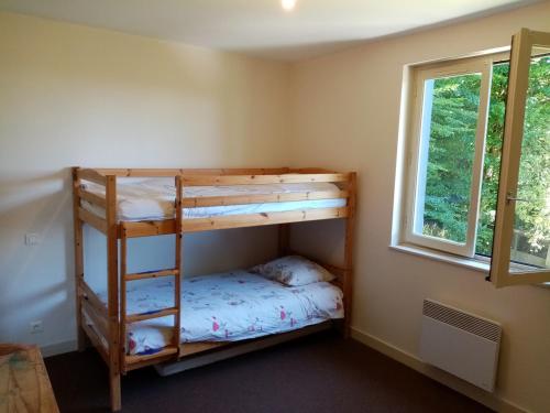 une chambre avec un lit superposé et une fenêtre dans l'établissement Gîte à la campagne, bain de soleil ou coin du feu, à Tulle