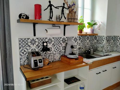 une cuisine avec des étagères en bois sur le mur dans l'établissement Le voyage chez pascale et yanis, à Ménil