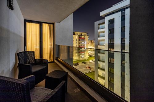 a balcony with chairs and a view of a city at Mirandis Apartments - Modern Stays with Free Parking near Coresi Mall in Braşov