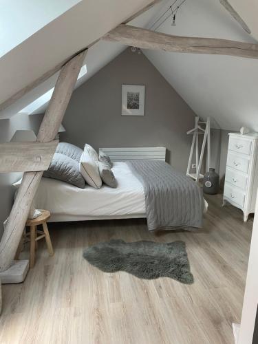 a bedroom with a bed in a attic at Le Passage Secret in Fleury-en-Bière