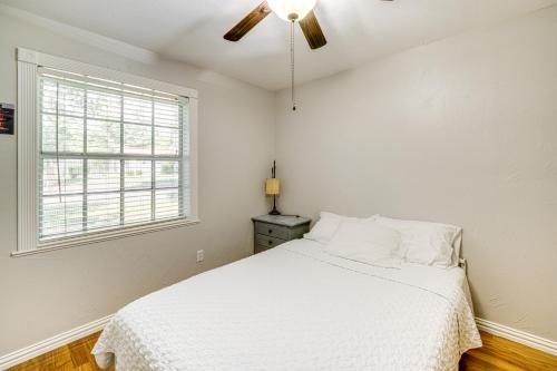 a white bedroom with a bed and a ceiling fan at Texas Home with Yard 2 Mi to Prairie Creek Park in Richardson