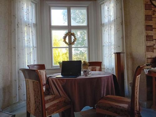 a table with a laptop on it in front of a window at Loma tai perhejuhlat Bobackan pihatorpassa in Hämeenlinna