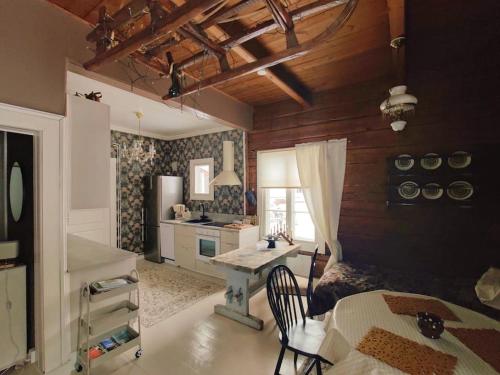 a kitchen with a table and a desk in a room at Loma tai perhejuhlat Bobackan pihatorpassa in Hämeenlinna