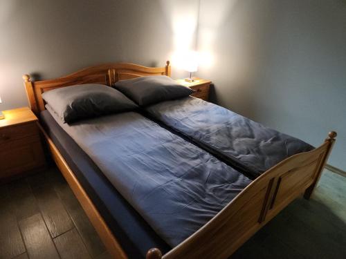 ein Bett mit blauer Bettwäsche und Kissen in einem Schlafzimmer in der Unterkunft Wilcza Poręba Apartament in Karpacz