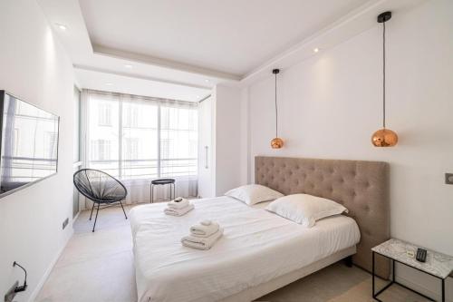 une chambre avec un grand lit avec deux serviettes dessus dans l'établissement 2 bedroom Grand Hotel with sea view 306, à Cannes