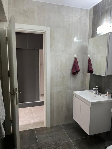 a bathroom with a white sink and a shower at Cyprus Chill Apartment in İskele
