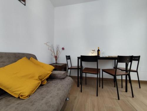 een woonkamer met een bank en een tafel met stoelen bij Apartamento Artesano Del Cuero SpaceWorking in Ubrique