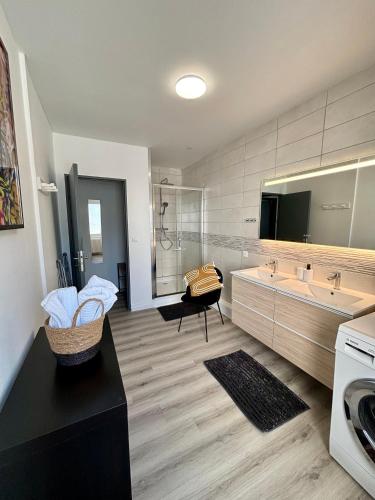 La grande salle de bains est pourvue de 2 lavabos et d'une baignoire. dans l'établissement L Alsacienne F2 centre ville, à Mulhouse