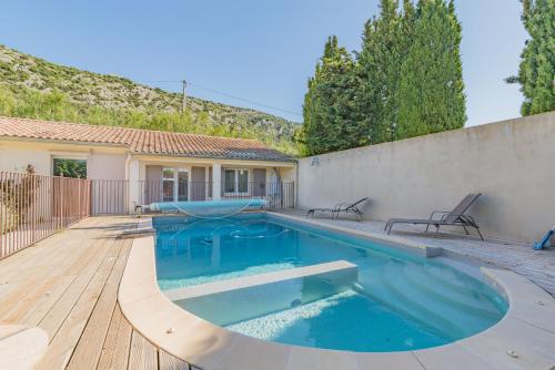 - une piscine dans un jardin avec une terrasse en bois dans l'établissement Domaine Purviti, à Beaumes-de-Venise
