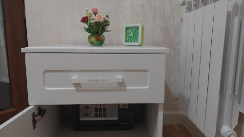 a white shelf with a vase with flowers in it at Banu House in Sumqayyt