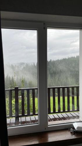 two windows in a room with a view of a field at Мелодія Гір .Апартаменти з видом на гори . in Vorokhta
