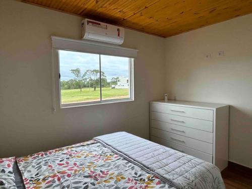 - une chambre avec un lit, une commode et une fenêtre dans l'établissement Riviera Santa Cristina XIII 05 suítes, à Palmeiras