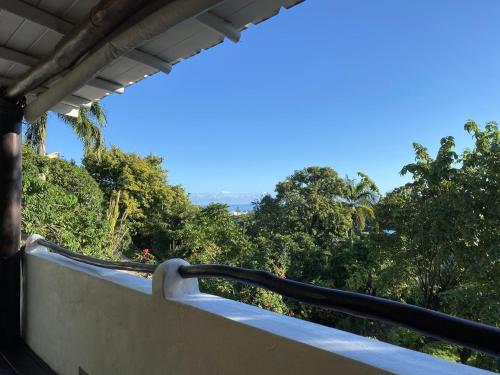 a balcony with a view of the trees at Propiedad de alto standing con vista al mar, piscina, tenis, hasta 12 personas in Las Terrenas