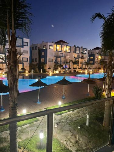 a swimming pool with umbrellas and buildings at night at complexe kariat cabo in Cabo Negro