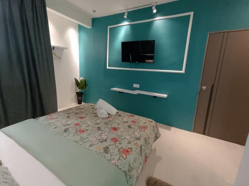a bedroom with a bed and a tv on the wall at Alameen Boutique Hotel in Kangar