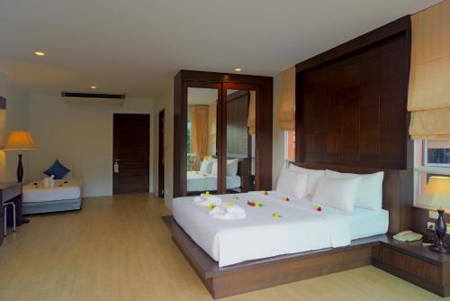 a bedroom with a large white bed and a bathroom at Aonang Regent Hotel in Ao Nang Beach