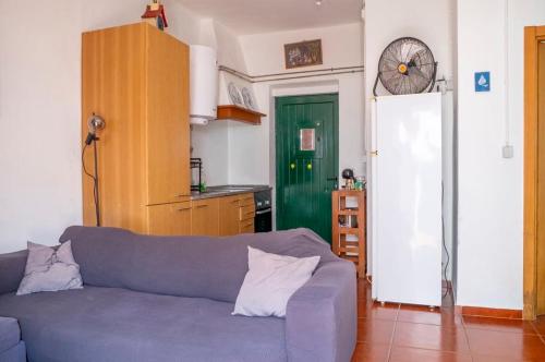 a living room with a blue couch and a green door at Front House in Lisbon