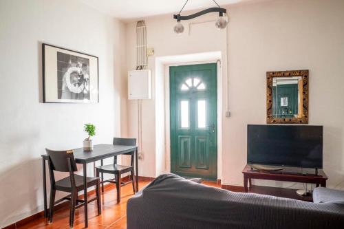 a living room with a table and a green door at Front House in Lisbon