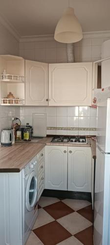 a kitchen with white cabinets and a washing machine at Zahara Lovers in Zahara de la Sierra