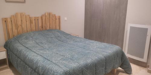 - un lit avec une couette bleue dans l'établissement Gîte L'hirondelle à St Antonin du Var, 2 chambres, à Masseboeuf