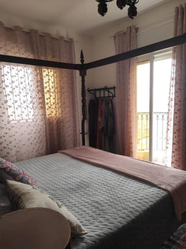 a bedroom with a canopy bed and a window at Dar Anjra in El Jandak