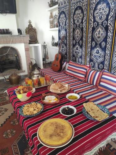 a table with many plates of food on a couch at Dar Anjra in El Jandak