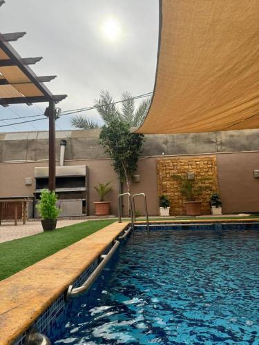 a swimming pool next to a building with a pool at Yasmina Chalet in Al Kafrayn