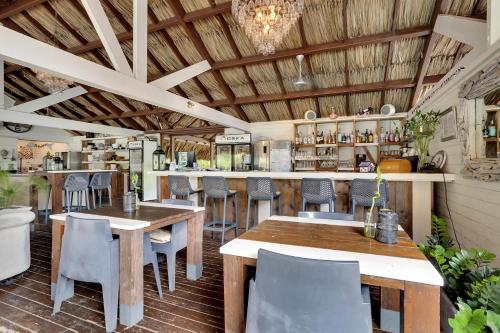 a restaurant with wooden ceilings and tables and chairs at Red Palm Village in Kralendijk