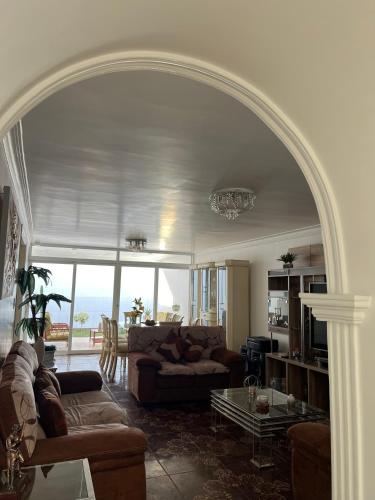 an archway in a living room with a couch and a table at Hermosa casa a 15 min de Paracas in Pisco