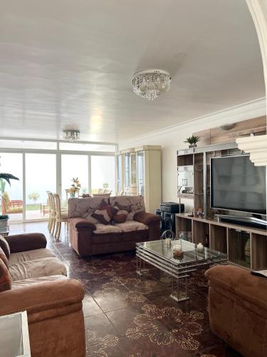 a living room with a couch and a tv at Hermosa casa a 15 min de Paracas in Pisco