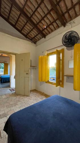 a bedroom with yellow cabinets and a bed in a room at HOSTEL DA LU e HOSPEDAGEM FATIMA in Pirenópolis