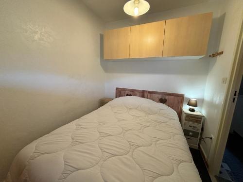 une petite chambre avec un lit et une armoire dans l'établissement Super Dévoluy résidence Les Issarts - Appart - 4 pers, à Saint-Étienne-en-Dévoluy
