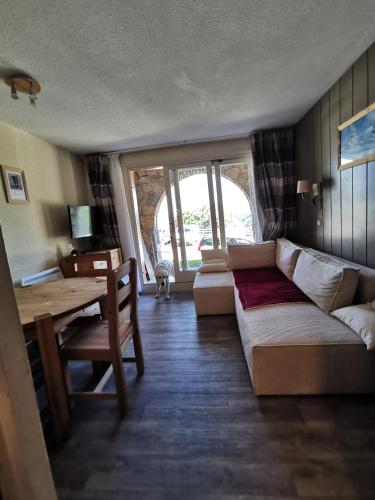 un salon avec un canapé et une table dans l'établissement Le Creux de l'Ours - au pied des pistes - animaux acceptés, à Méribel