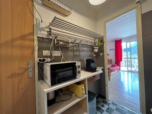 Il comprend une cuisine avec un bureau et un four micro-ondes. dans l'établissement Super Dévoluy résidence Les Issarts - Appart - 4 pers, à Saint-Étienne-en-Dévoluy