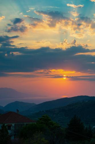 a sunset with the sun setting over the mountains at Idyllia 1 in Písia