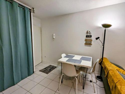 une pièce avec une table, des chaises et un canapé dans l'établissement Grand studio proche de la GARE., à Grenoble